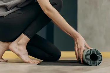 Person rolling up a yoga mat