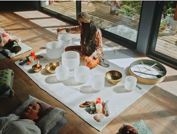Sound bath session with crystal singing bowls and participants resting